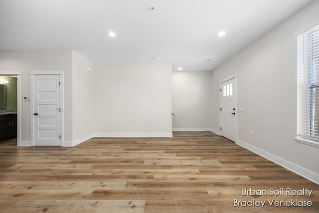 empty room featuring a healthy amount of sunlight and light hardwood / wood-style flooring