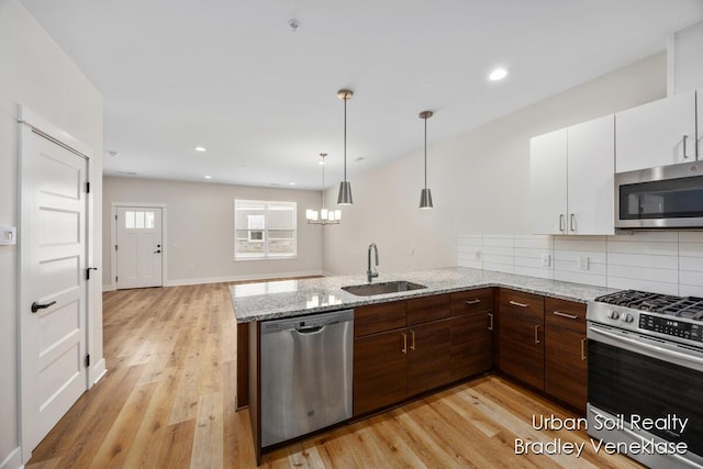 kitchen featuring sink, white cabinets, stainless steel appliances, and light hardwood / wood-style floors