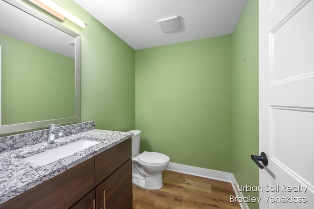 bathroom featuring hardwood / wood-style flooring, vanity, and toilet