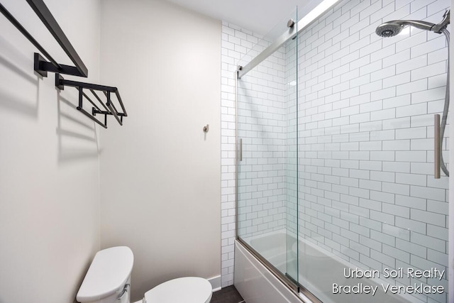 bathroom with enclosed tub / shower combo and toilet