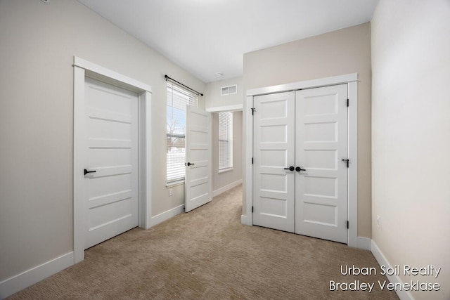 unfurnished bedroom with light colored carpet