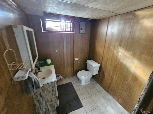 bathroom featuring wood walls, tile patterned flooring, vanity, and toilet