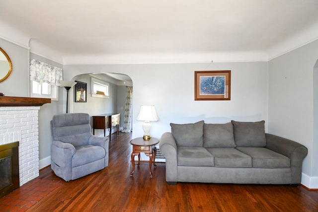 living room with dark hardwood / wood-style flooring and a fireplace