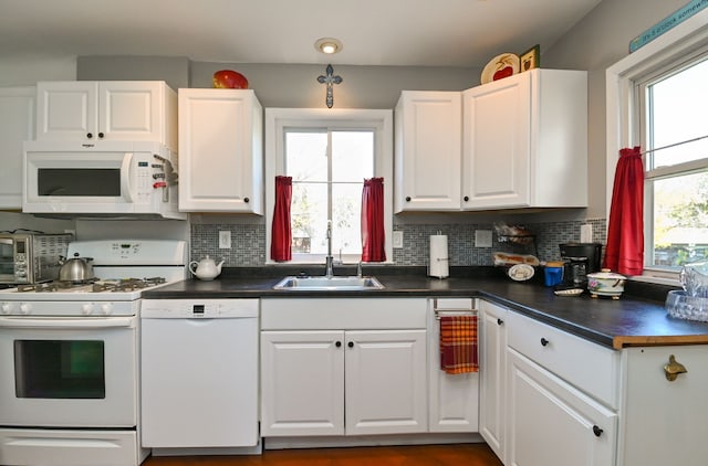 kitchen featuring white cabinetry, white appliances, sink, and tasteful backsplash