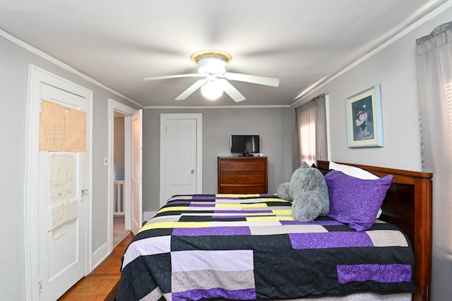 bedroom with hardwood / wood-style floors, ceiling fan, and ornamental molding