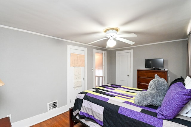 bedroom with connected bathroom, hardwood / wood-style flooring, ceiling fan, and crown molding