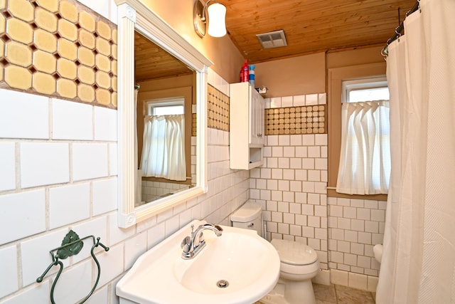 bathroom with tile patterned floors, wood ceiling, sink, tile walls, and toilet