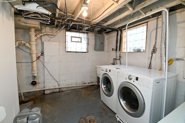 laundry area featuring a healthy amount of sunlight, washing machine and dryer, and electric panel