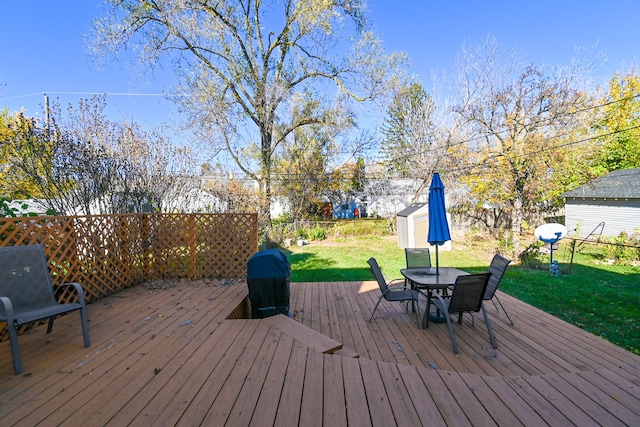 deck featuring a lawn and a storage unit