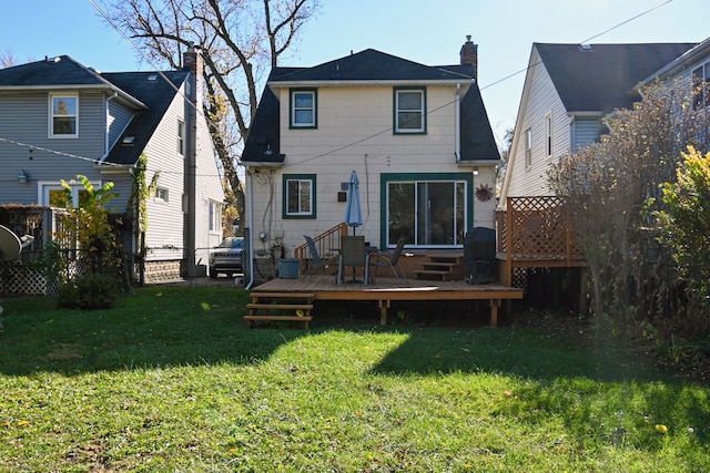 back of house featuring a lawn and a deck