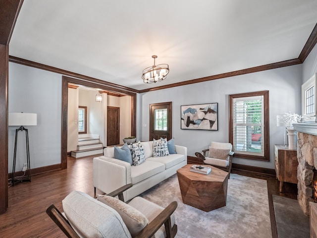 living room featuring ornamental molding, dark wood-type flooring, and an inviting chandelier