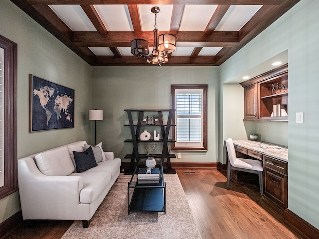 living room with coffered ceiling, an inviting chandelier, beamed ceiling, wood-type flooring, and built in desk