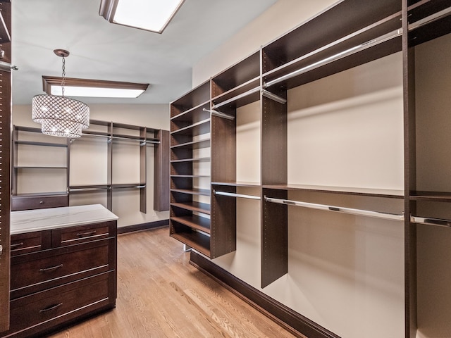 spacious closet with lofted ceiling and light wood-type flooring