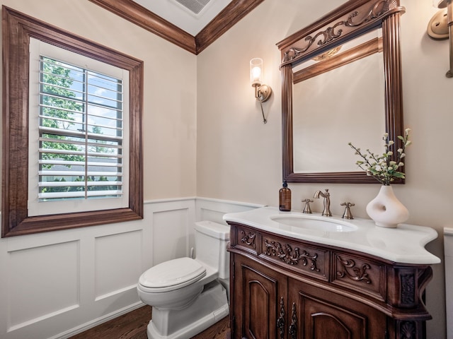 bathroom with wood-type flooring, vanity, toilet, and crown molding