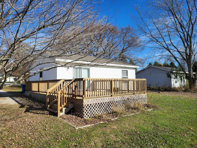 back of house with a deck and a yard