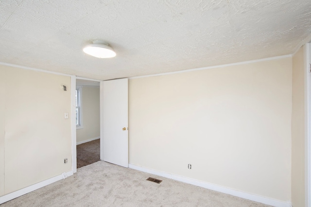 carpeted empty room with a textured ceiling