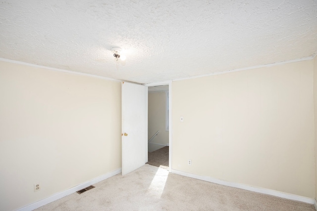 carpeted spare room featuring a textured ceiling