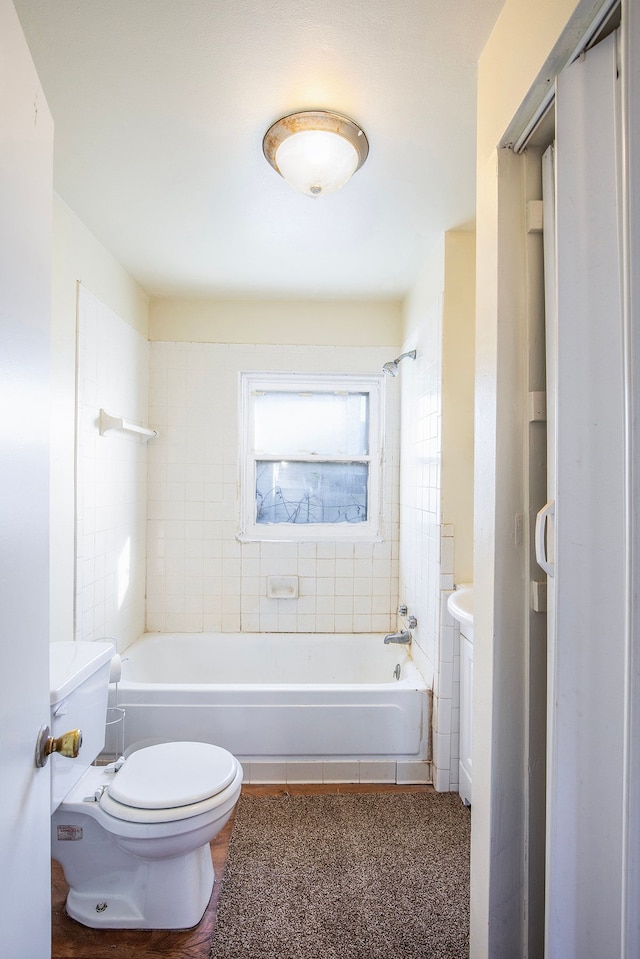 bathroom featuring toilet and tiled shower / bath