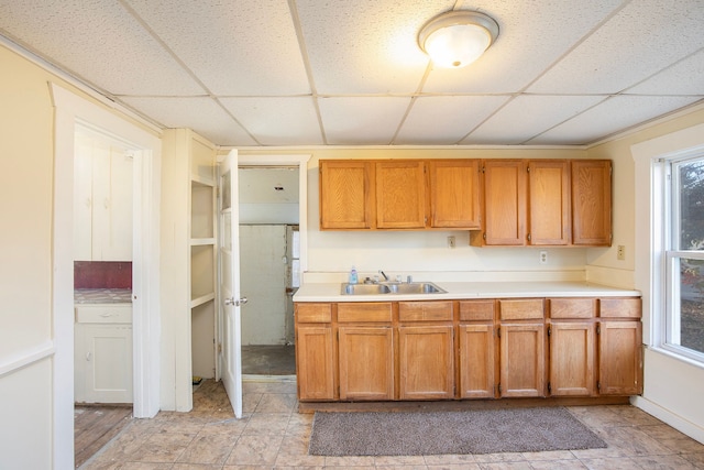 kitchen featuring sink, light tile patterned flooring, and a drop ceiling