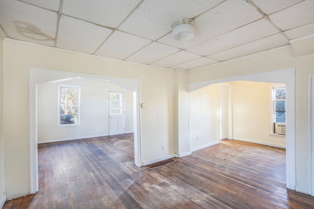 unfurnished room featuring a drop ceiling and dark wood-type flooring