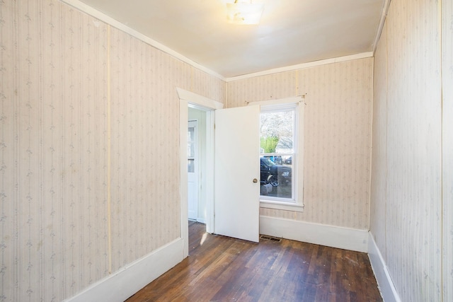 empty room with dark hardwood / wood-style floors and ornamental molding