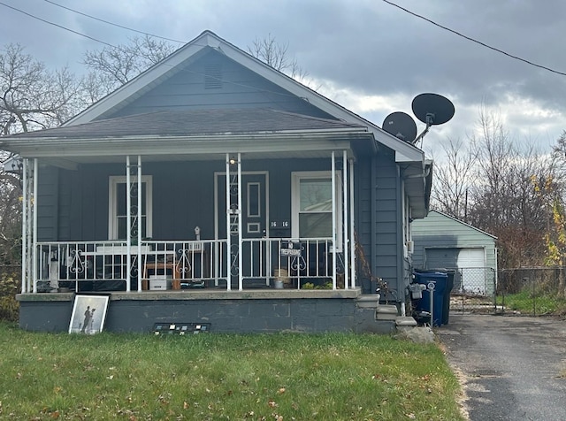 view of property exterior with covered porch, a garage, and an outdoor structure