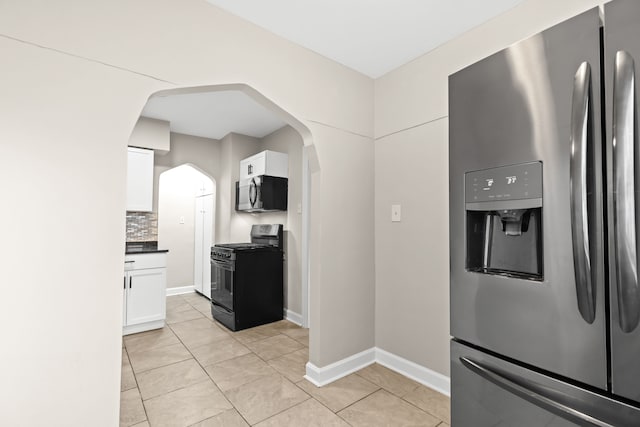 kitchen with white cabinetry, stainless steel appliances, light tile patterned floors, and tasteful backsplash