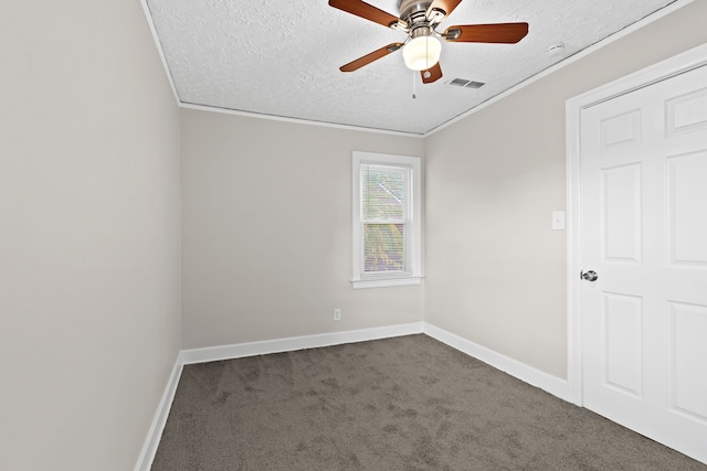 carpeted spare room featuring ceiling fan, ornamental molding, and a textured ceiling