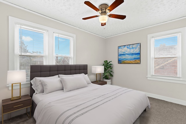 bedroom featuring multiple windows, a textured ceiling, carpet floors, and ceiling fan