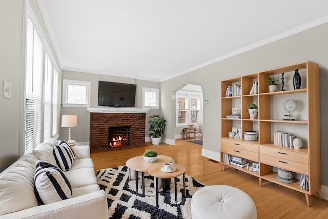 living room featuring a fireplace, hardwood / wood-style flooring, and ornamental molding