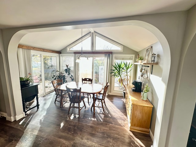 dining room with dark wood-type flooring, vaulted ceiling, and an inviting chandelier