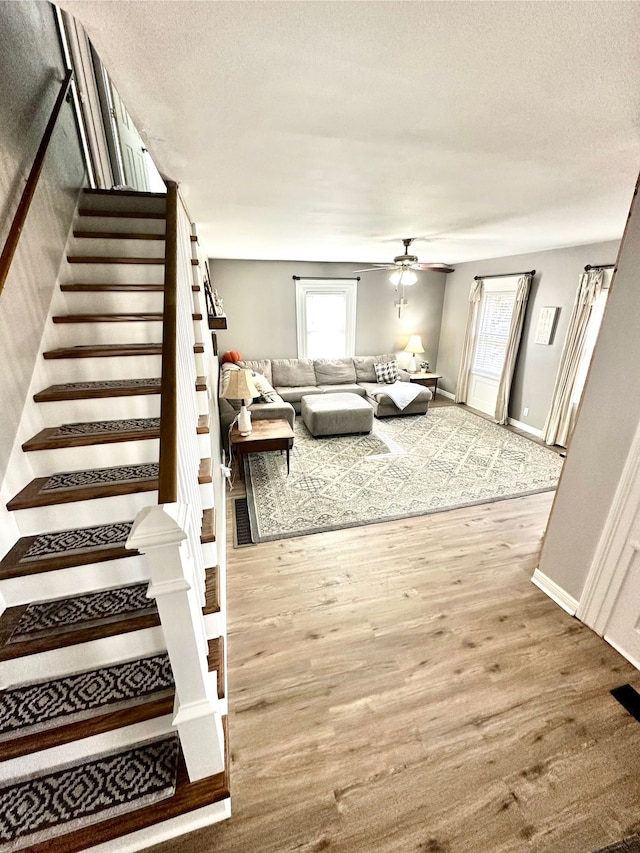 unfurnished living room with hardwood / wood-style floors, a textured ceiling, and ceiling fan