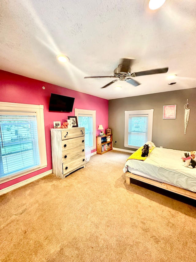 bedroom featuring carpet flooring, a textured ceiling, and ceiling fan