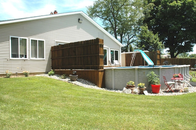 exterior space with a fenced in pool and a yard