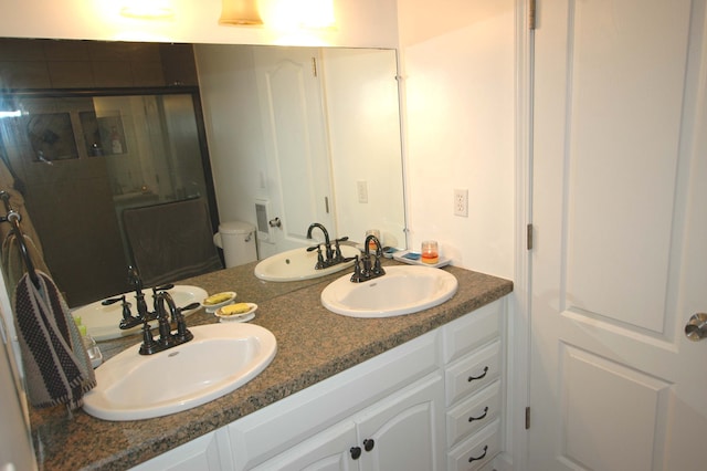 bathroom with vanity, an enclosed shower, and toilet