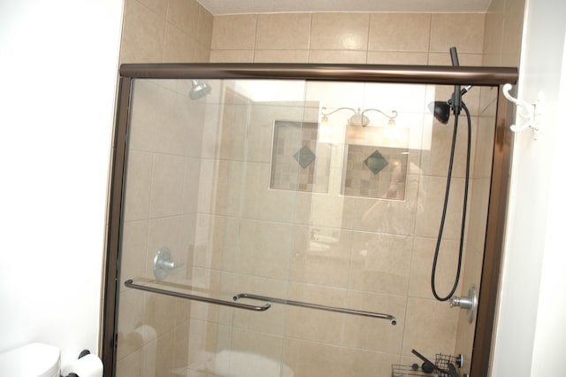 bathroom with toilet and a shower with shower door