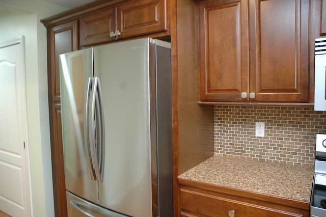 kitchen with appliances with stainless steel finishes and tasteful backsplash