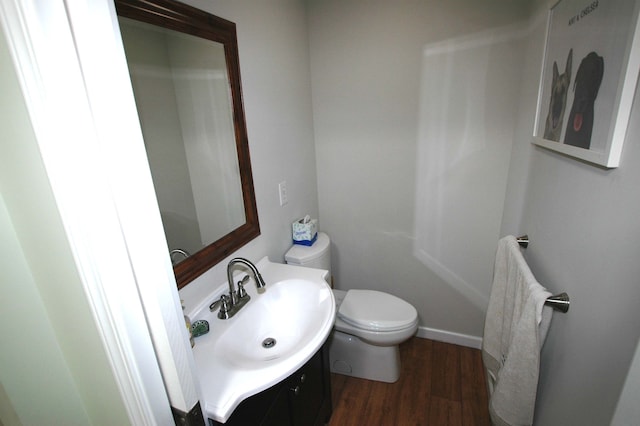 bathroom with toilet, vanity, and hardwood / wood-style flooring