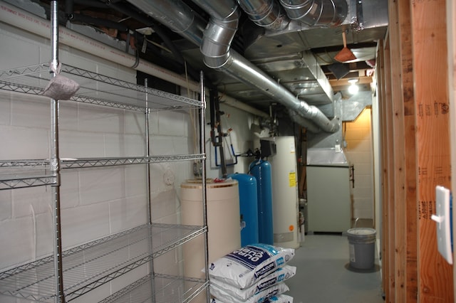 utility room featuring heating unit and water heater