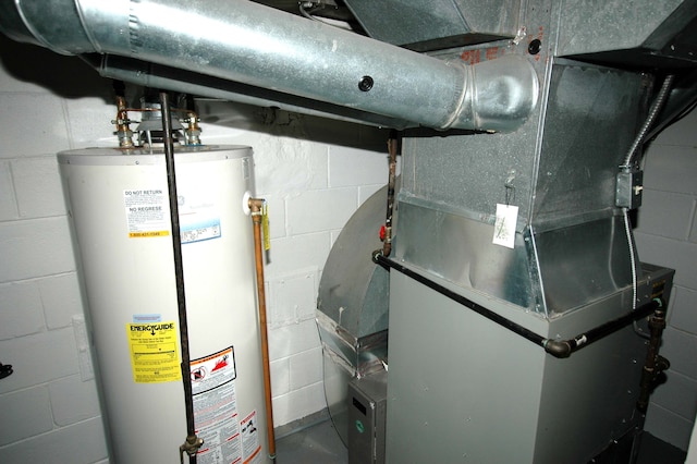 utility room with heating unit and water heater