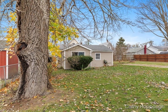 view of home's exterior featuring fence and a yard