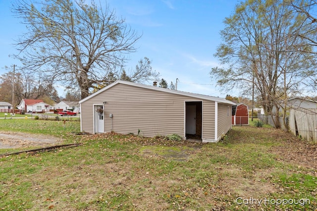 view of outdoor structure with a residential view, fence, and an outdoor structure