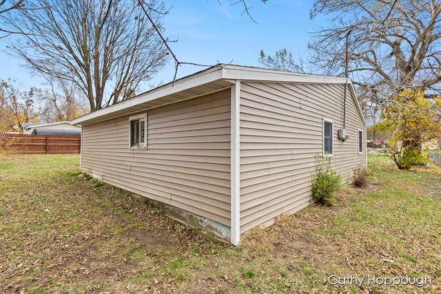 view of property exterior featuring fence and a lawn