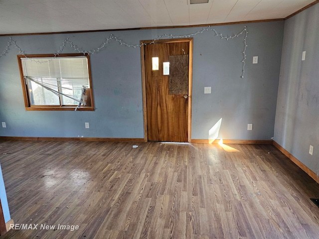 unfurnished room with hardwood / wood-style flooring and ornamental molding