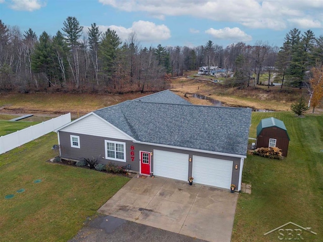 ranch-style home with a storage shed, a front lawn, and a garage