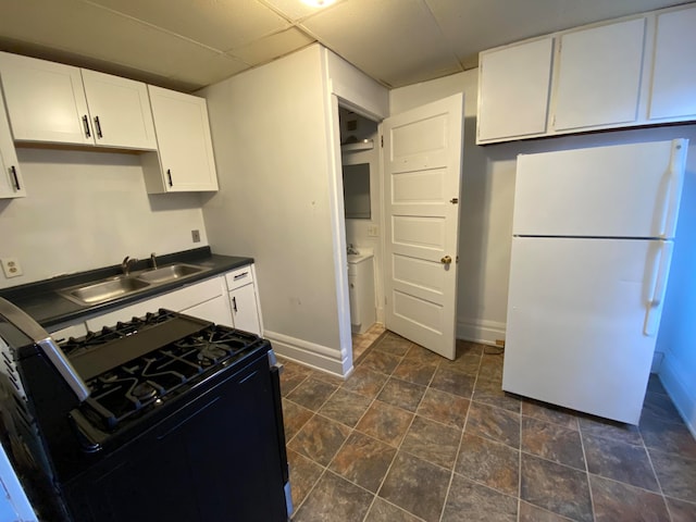 kitchen featuring white cabinets, white fridge, black gas stove, and sink