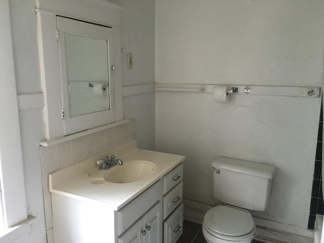 bathroom featuring vanity, tasteful backsplash, and toilet