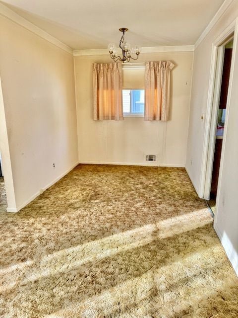 carpeted spare room featuring a chandelier and ornamental molding