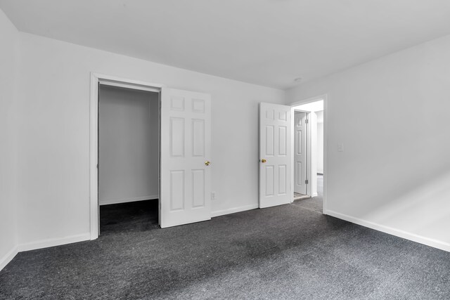 10420 Whittier St, Detroit, MI 48224 - unfurnished bedroom featuring dark colored carpet and baseboards