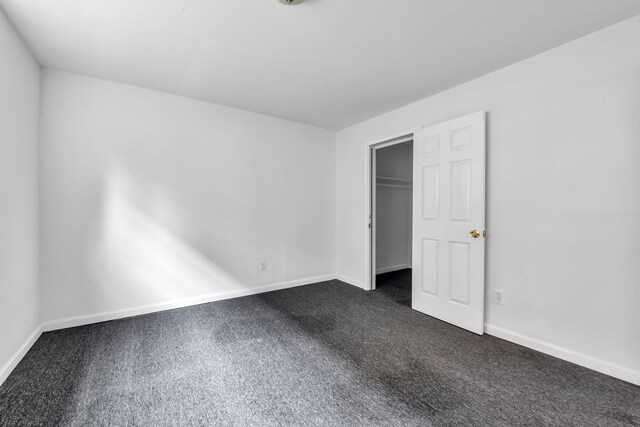 10420 Whittier St, Detroit, MI 48224 - unfurnished bedroom with baseboards, dark colored carpet, and a closet